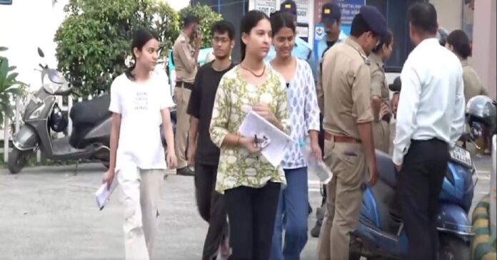 री-नीट परीक्षा केंद्र के बाहर सुरक्षा जांच के लिए खड़े अभ्यर्थी