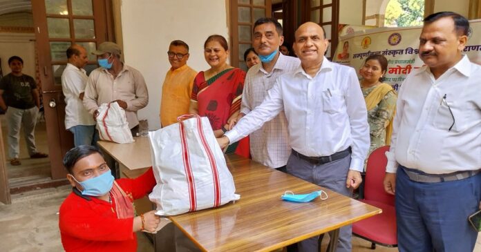 सम्पूर्णानन्द संस्कृत विश्वविद्यालय में टीबी मरीजों को पोषण पोटली वितरित करते कुलसचिव राकेश कुमार