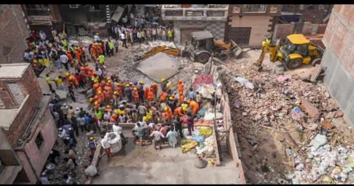 हर्ष विहार के मिलन गार्डन में मकान की छत गिरने के बाद मलबे में लोगों की तलाश करते बचावकर्मी।